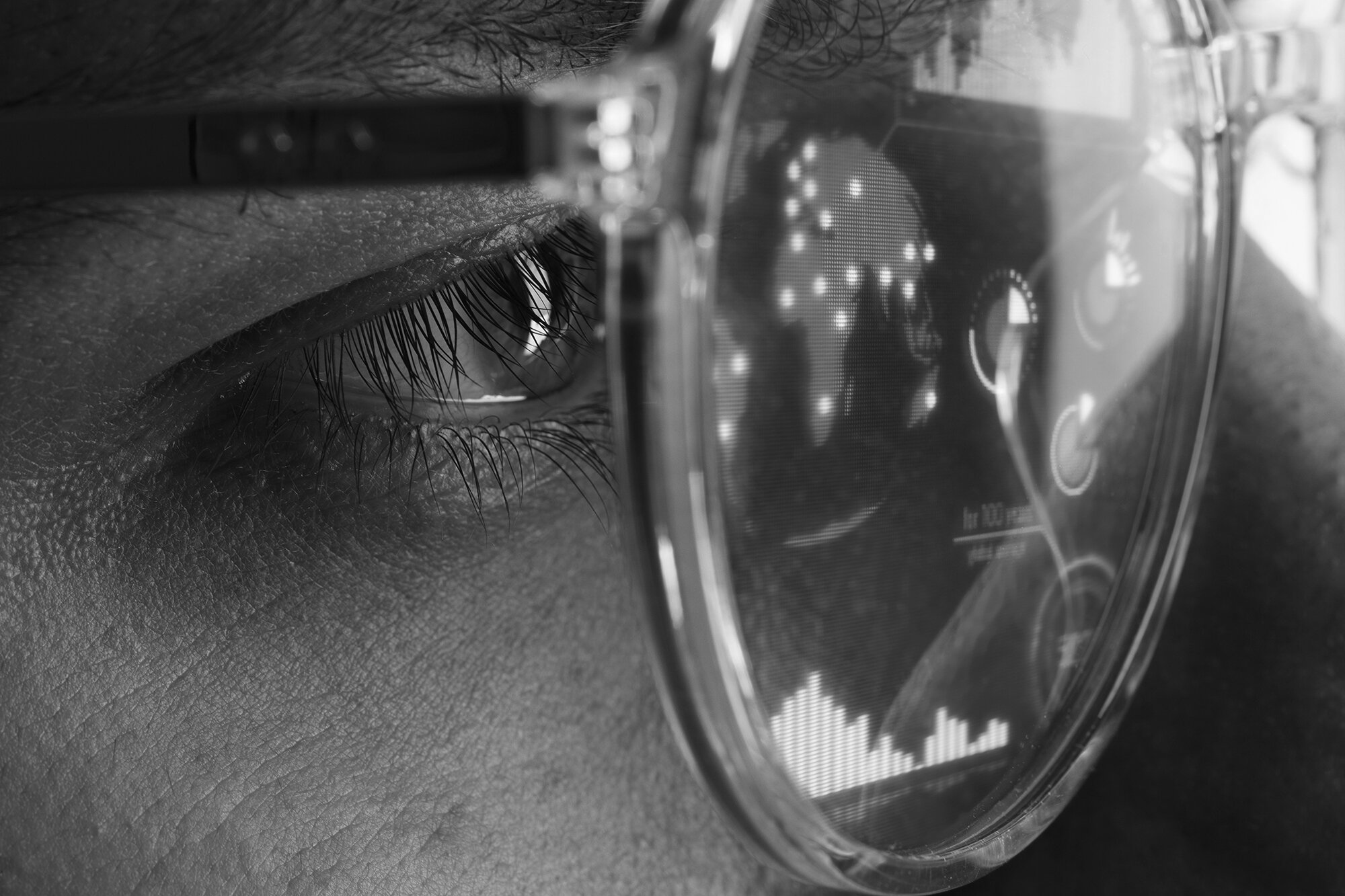 Nahaufnahme eines menschlichen Auges, das durch eine Brille betrachtet wird